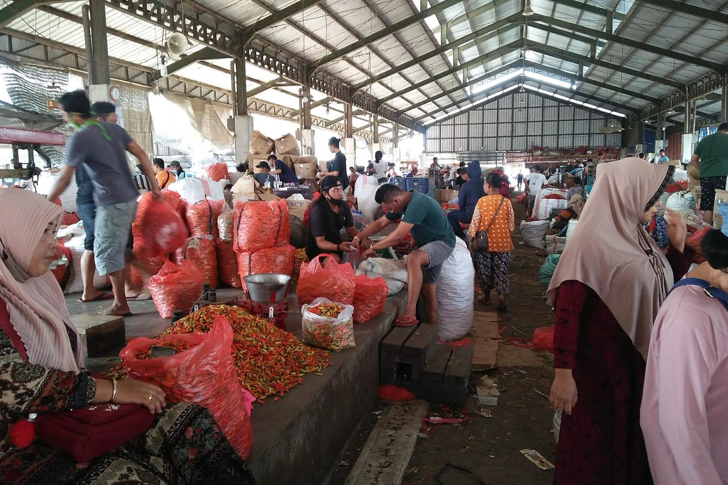 Para pedagang dan pembeli di antara karung-karung cabai di Pasar Induk Pare, Kediri