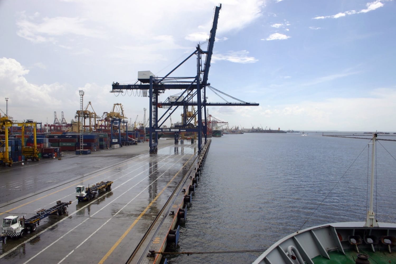 Derek peti kemas dan truk di dermaga terminal peti kemas Tanjung Priok, Jakarta, dilihat dari kapal