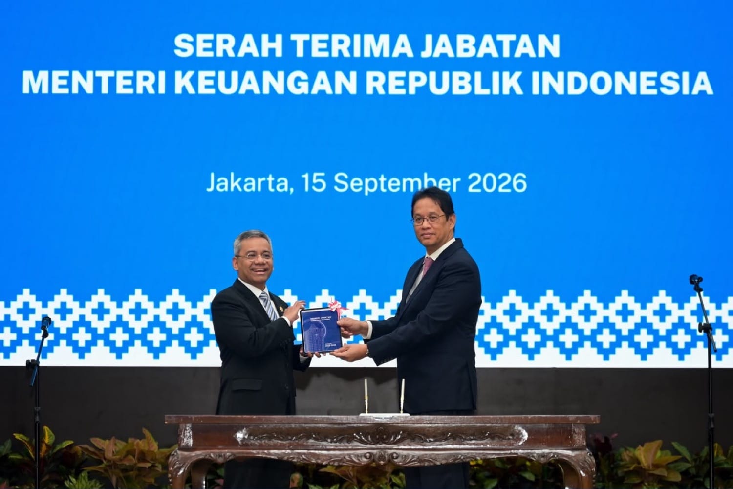 Dua pejabat bertukar dokumen serah terima di depan layar bertuliskan Serah Terima Jabatan Menteri Keuangan Republik Indonesia, Jakarta, 15 September 2026